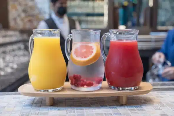 Sucos naturais de frutas ricos em vitaminas servidos em jarras, ideais para fortalecer a imunidade