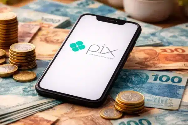 Smartphone exibindo o Pix sobre cédulas de real, representando ganhar dinheiro no Pix de verdade em 2026