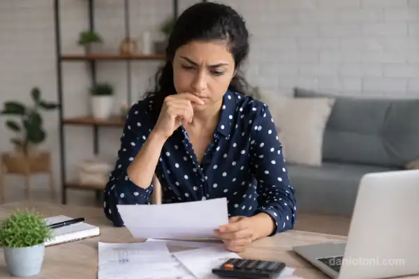 Antecipar FGTS para quitar dívidas em 2026 com pessoa analisando contas, calculadora e documentos em uma simulação de perda financeira